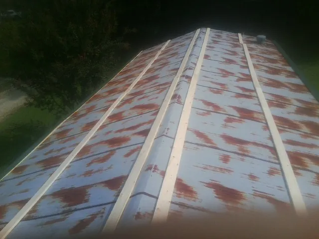 Rusted metal roof panels with new wood purlins before replacement — Storm Damage Roof Repair in Rice by Roofing Brothers